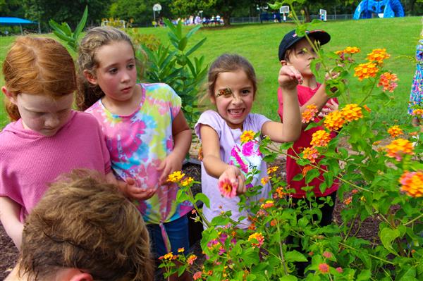 students in a flower garden with butterflies